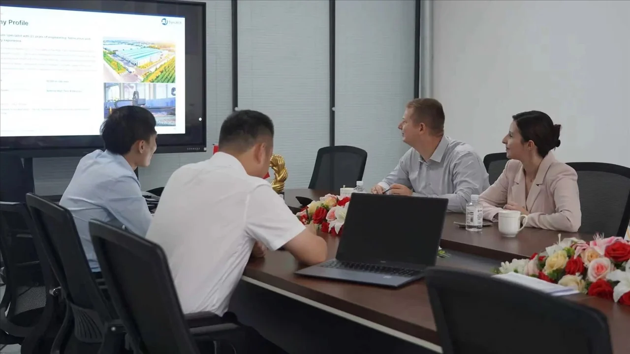 Buyers and supplier representatives seated around a meeting table during a company presentation
