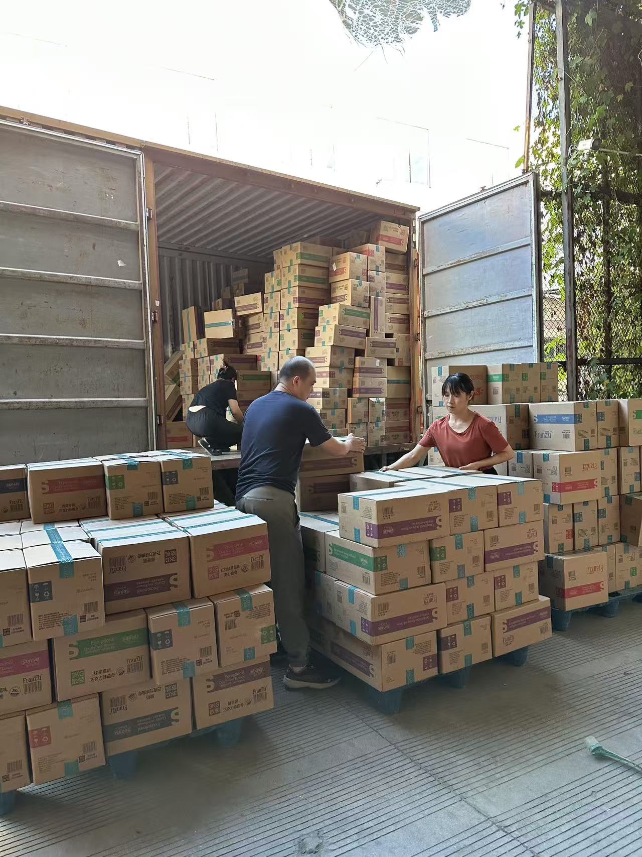 Workers loading packaged snack cartons onto a truck