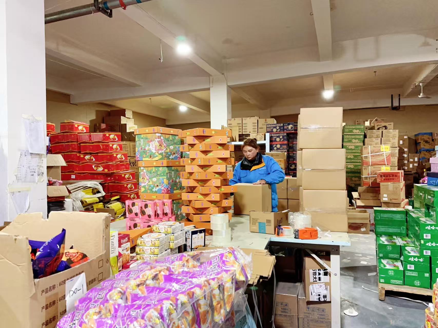 A worker packing snack cartons at NitaSource's cooperating supplier